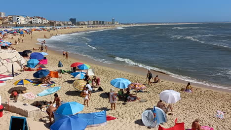 Playa-De-Buarcos-Durante-La-Temporada-De-Baño,-Llena-De-Gente-Y-Sombrillas-A-Lo-Largo-De-La-Playa.