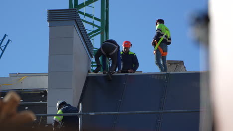 Workers-installing-solar-panels-on-the-roof-of-a-newly-constructed-house