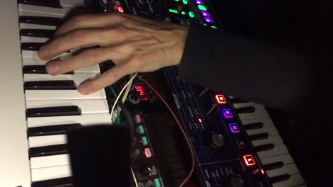 Hand-Eines-Elektronischen-Musikers-Auf-Tastatur-Und-Synthesizer-Mit-Blinkenden-LEDs,-Nahaufnahme-In-Zeitlupe