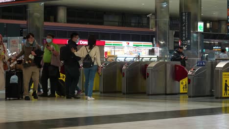 Passengers-traveling-with-luggages-access-airport-connecting-networks-at-arrival-and-departure-hall-of-Taoyuan-High-Speed-Rail-Station,-Taiwan-tourism,-static-shot-at-the-ticket-barriers-gate