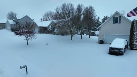 Bandera-Americana-Ondeando-Frente-A-La-Casa-Cubierta-De-Nieve-Con-Una-Camioneta-Ford-En-La-Entrada