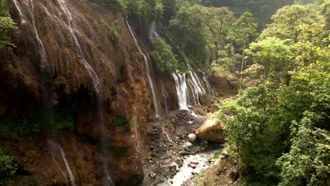 a-precarious-landscape-prone-to-landslides,-where-rivers-carve-through-rugged-terrain,-punctuated-by-numerous-small-waterfalls-cascading-amidst-the-perilous-beauty-of-nature's-raw-power