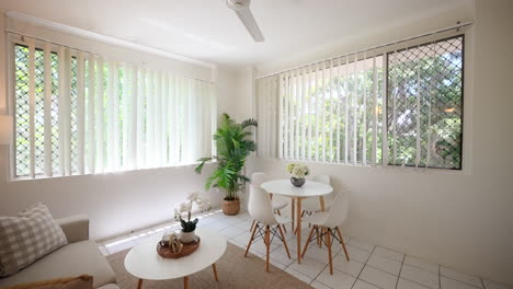 Kompakter-Tropischer-Wohnzimmer-Gemeinschaftsbereich-Mit-Couchtisch-Und-Stühlen-In-Tropischer-Umgebung
