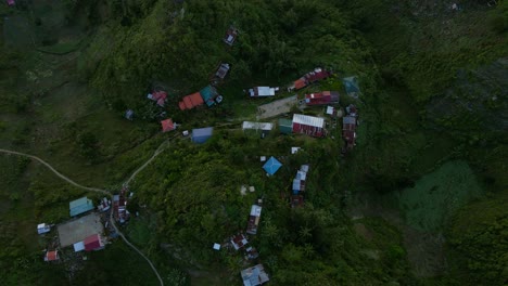 Un-Pueblo-Remoto-Enclavado-En-Las-Exuberantes-Montañas-Verdes-De-Filipinas-Al-Atardecer,-Vista-Aérea