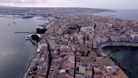 Establishing-aerial-of-Ortigia-Island-at-twilight,-Sicily,-Italy