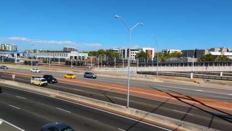 Dolly-right-clip-of-freeway-traffic-from-above-with-Perth-train-coming-into-Claisebrook-station