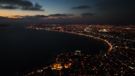 Mazatlan-city,-wide-aerial-of-the-illuminated-coastline-of-Sinaloa,-dusk-in-Mexico