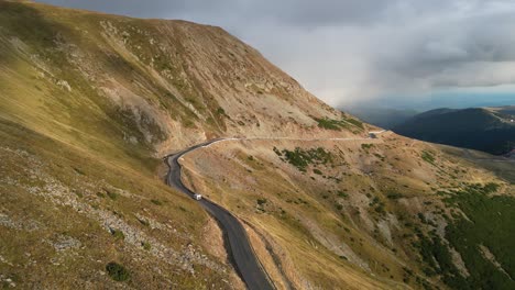 RV-Camper-drives-Transalpina-Mountain-Road-in-Carpathians,-Romania---Aerial-4k