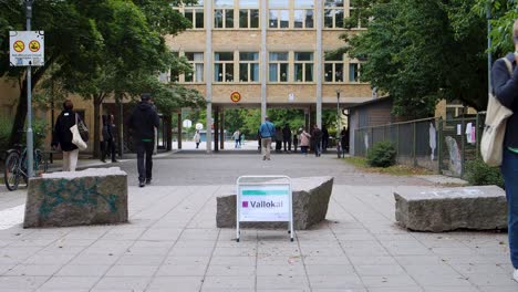 People-walk-towards-voting-station-in-Stockholm,-Sweden,-during-election-day,-street-view