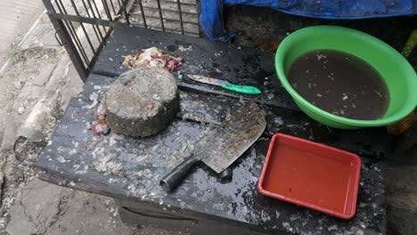 Traditional-outdoor-fish-cleaning-station-with-chopping-board,-knife,-and-basin