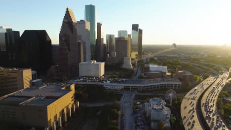 Aerial-view-circling-the-westside-of-the-Houston-skyline,-sunset-in-Texas,-USA