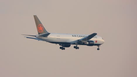 Cargo-plane-begins-descent-waving-wings-and-maple-leaf-emblem-as-it-lands-against-city-skyline-of-Toronto-Canada-International-Airport