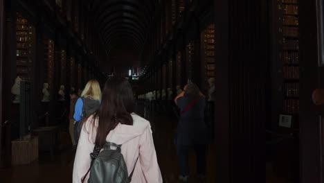 La-Cámara-Que-Sigue-A-La-Joven-Revela-La-Larga-Sala-De-La-Antigua-Biblioteca-Del-Trinity-College.