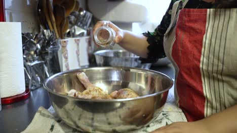 Primer-Plano-De-Las-Manos-Sazonando-El-Pollo-En-Un-Tazón,-Ambiente-De-Cocina,-Ambiente-De-Cocina-Casera