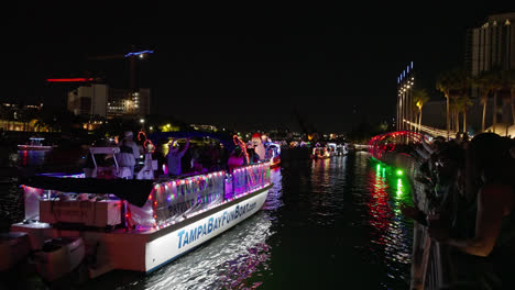 Large-party-boat-flashes-lights-in-Christmas-holiday-parade-on-the-water-at-night