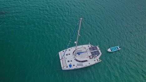 Revealing-Top-View-of-Anchored-Catamaran-in-Turquoise-Waters,-Las-Terrenas