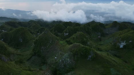 Lush-green-hills-of-Osmena-Peak-under-a-misty-sky-at-dawn,-aerial-shot