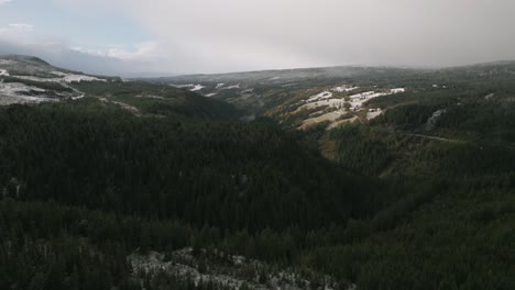 Lush-green-valley-with-patches-of-snow,-aerial-view-in-Norway,-serene-landscape