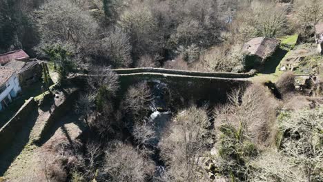 Aerial-pullback-along-river-above-Navea-Bridge-Ourense-Spain