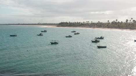 Vista-Aérea-De-Los-Barcos-Estacionados,-La-Zona-De-Palmeras-En-Un-Día-Nublado,-Guarajuba,-Bahía,-Brasil.