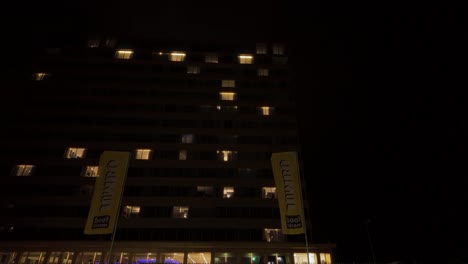 Reveal-of-flat-building-through-shabby-plastic-house-urban-night-cityscape