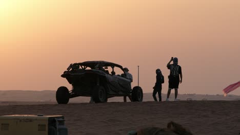 Dune-buggy-adventure-at-sunset-in-Dubai-desert,-silhouette-of-buggy-and-person