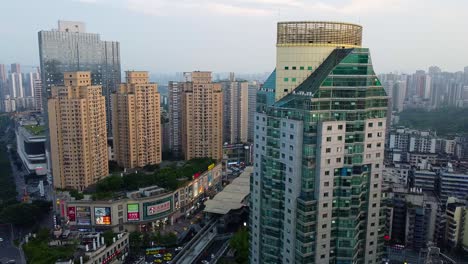 Modernes-Stadtbild-In-Der-Abenddämmerung-Mit-Beleuchteten-Gebäuden,-Schildern-Und-Belebten-Straßen-In-China,-Luftaufnahme