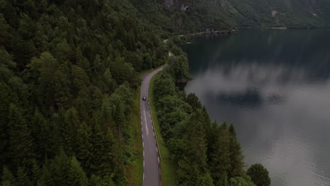Car-Driving-Along-Lakeside-Road-Next-to-Eikesdalsvatnet-Lake-in-Norway,-Aerial-View
