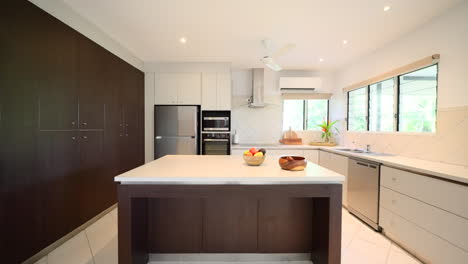 White-and-Tan-brown-kitchen-with-leather-furniture-dolly-to-fruit-bowl-and-tropical-plants-on-countertops