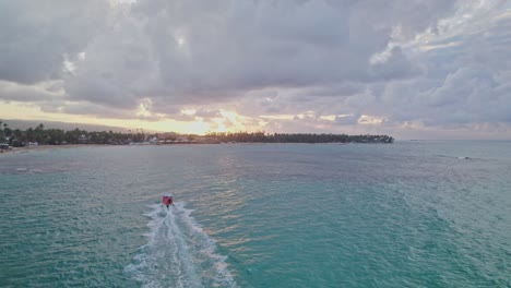 Seguimiento-Aéreo-De-Un-Barco-De-Excursión-Al-Atardecer-En-Las-Terrenas,-República-Dominicana