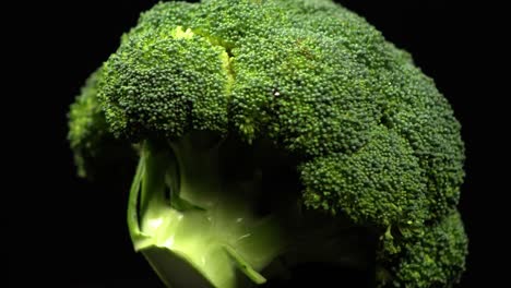 Close-up-macro-of-fresh-big-broccoli-rotating-on-a-black-background