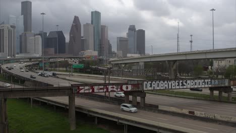 Descending-drone-shot-of-downtown-Houston-cityscape-that-reveals-a-large-alligator-in-the-Buffalo-Bayou