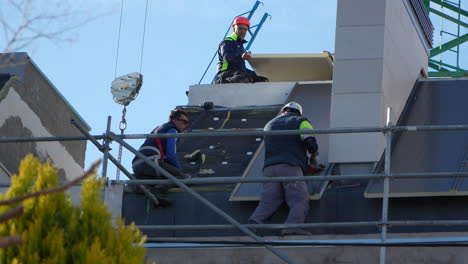 Profesionales-Instalando-Paneles-Solares-En-El-Techo-De-Una-Casa-De-Barrio-De-Clase-Alta.