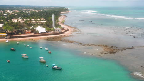 Vista-Aérea-De-La-Playa-Praia-Do-Forte,-El-Arrecife-De-Coral,-Barcos-Estacionados,-área-De-Palmeras-En-Un-Día-Nublado,-Praia-Do-Forte,-Bahia,-Brasil