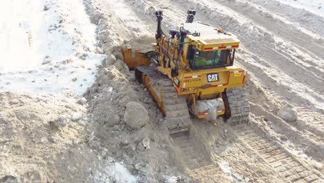 Bulldozer-tracks-push-and-clear-dirty-snow-fall-melting-slush-to-clear-access-roads-in-Montreal-Canada