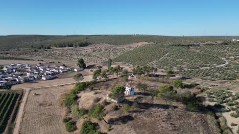 Aerial-of-La-Ermita-del-Poblado-de-San-Julián,-a-symbol-of-faith-and-reverence-standing-tall-amidst-the-quaint-charm-of-Marmolejo