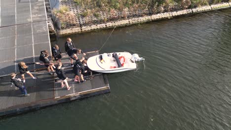 Leute-Von-Einem-Ruderclub-Setzen-Ein-Ruderboot-Vom-Dock-Aus-Ins-Wasser