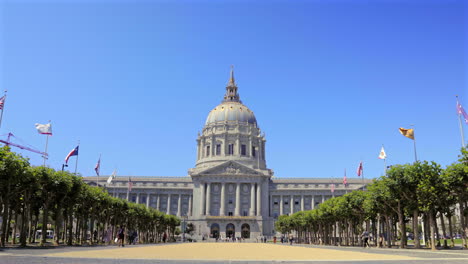 Ayuntamiento-De-San-Francisco-En-Un-Día-Claro,-Banderas-Ondeando,-Cielo-Azul