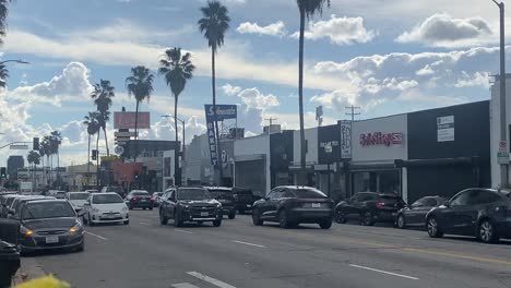 Corner-of-Fairfax-and-Rosewood-with-vehicles-driving-by-in-Los-Angeles,-California-with-stable-video