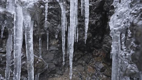Icicles-hanging-from-rocky-ledge,-clear-and-sharp-with-details-visible