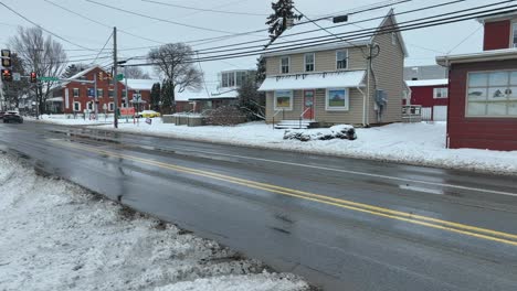 Amish-horse-and-buggy-passing-drone-in-Intercourse,-Pennsylvania-after-snow-storm-in-winter