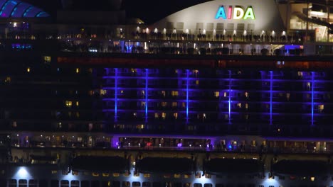 Aida-COSMA-ocean-liner-leaving-the-Port-of-Funchal-at-night-showcasing-the-colorful-neon-lights-of-the-cruiser-ship