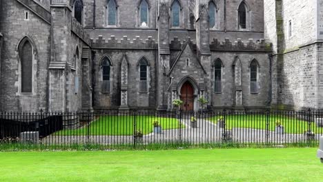 Tourist-woman-walking-in-front-of-St-Patrick's-Cathedral-in-a-sunny-day,-Dublin