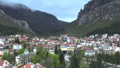 Drone-shot-of-a-small-village-next-to-a-mountain