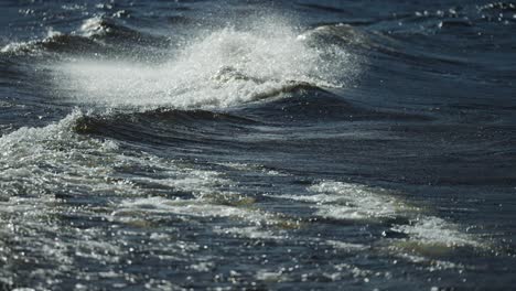 Long-white-crested-waves-crash-onto-the-pebble-beach