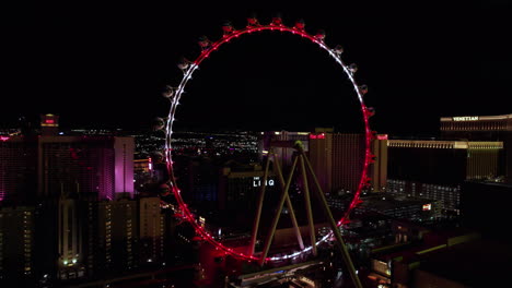 Aerial-View-of-Las-Vegas-High-Roller-Wheel-at-Night,-The-Linq-Hotel-and-Casino-and-Strip,-Drone-Shot