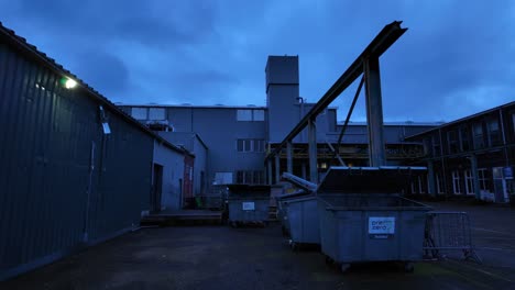 Mülltonnen-In-Einem-Industriehof-In-Einer-Tristen-Lage-Während-Der-Dämmerung
