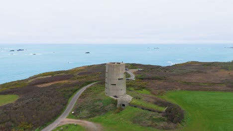 Guernsey-Pleinmont-flight-over-German-watchtower-heading-over-headland-on-southwest-tip-of-the-Island-and-out-to-sea-on-bright-cloudy-day