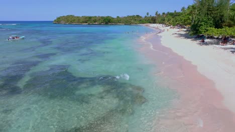 Drone-flyover-sandy-beach-and-clear-water-with-many-tourist-in-water