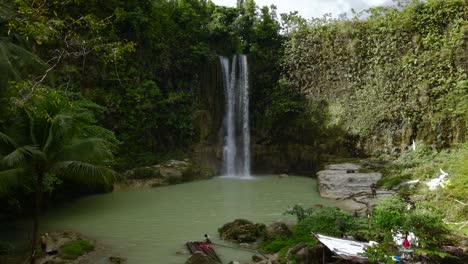 Lush-Camugao-Falls-cascading-into-serene-pool-in-the-Philippines,-surrounded-by-tropical-foliage